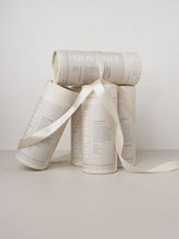 Load image into Gallery viewer, Three cylindrical containers with a ribbon on a light gray background