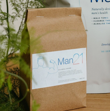 Load image into Gallery viewer, Man21 product packaging on a wooden surface with plants in the foreground