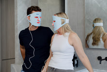 Load image into Gallery viewer, Two people using LED face masks in a bathroom setting.