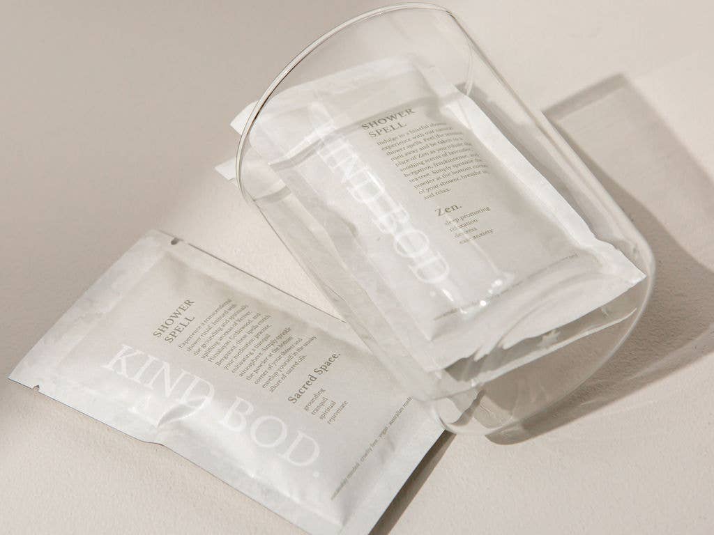 Clear container with white packets labeled 'Kind Body' on a light background